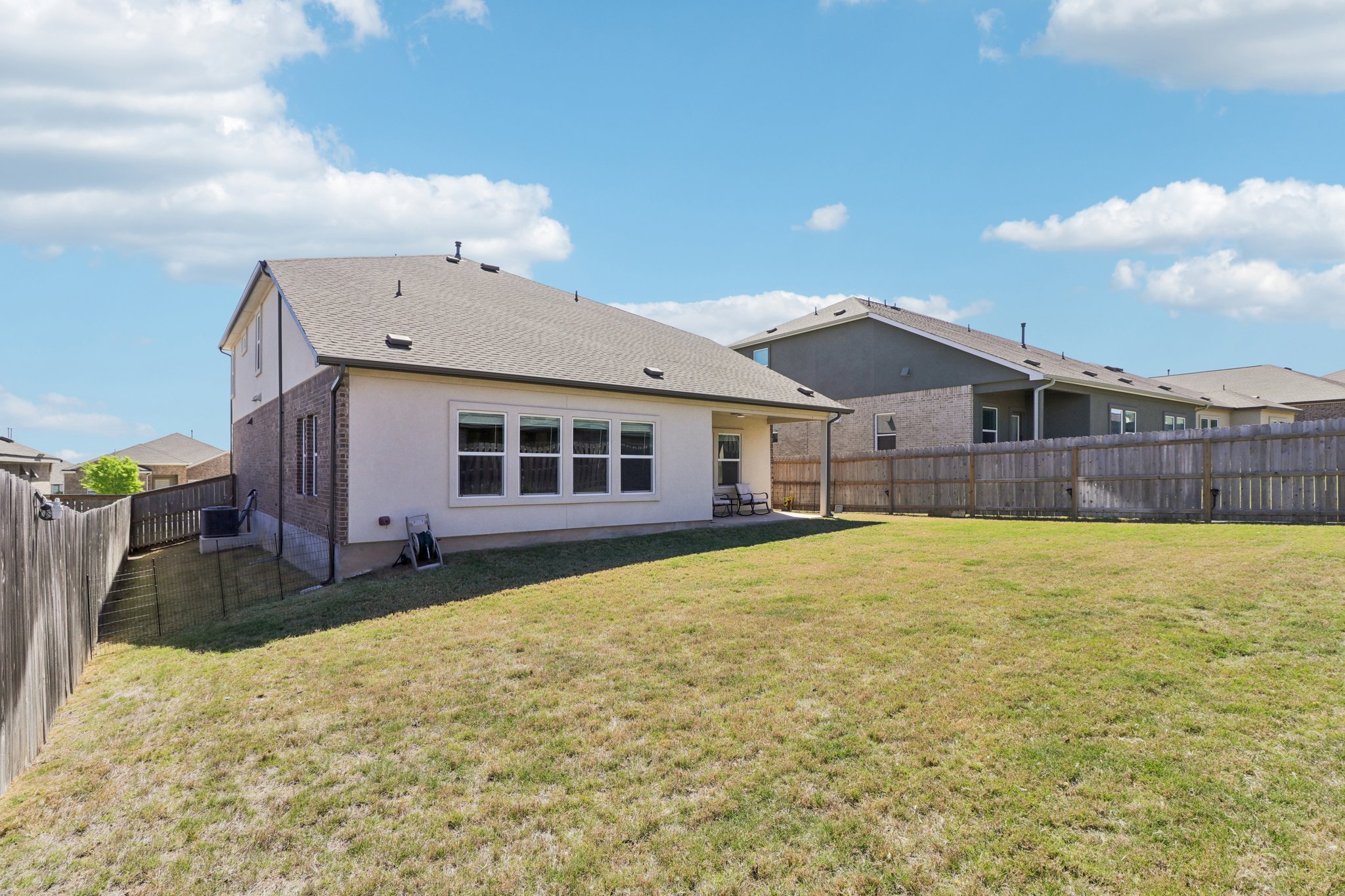 1201 Mallow Road Leander, TX 78641 - Photo 39 of 40 Rear view of house with a patio area, a fenced backyard, brick siding, and a shingled roof