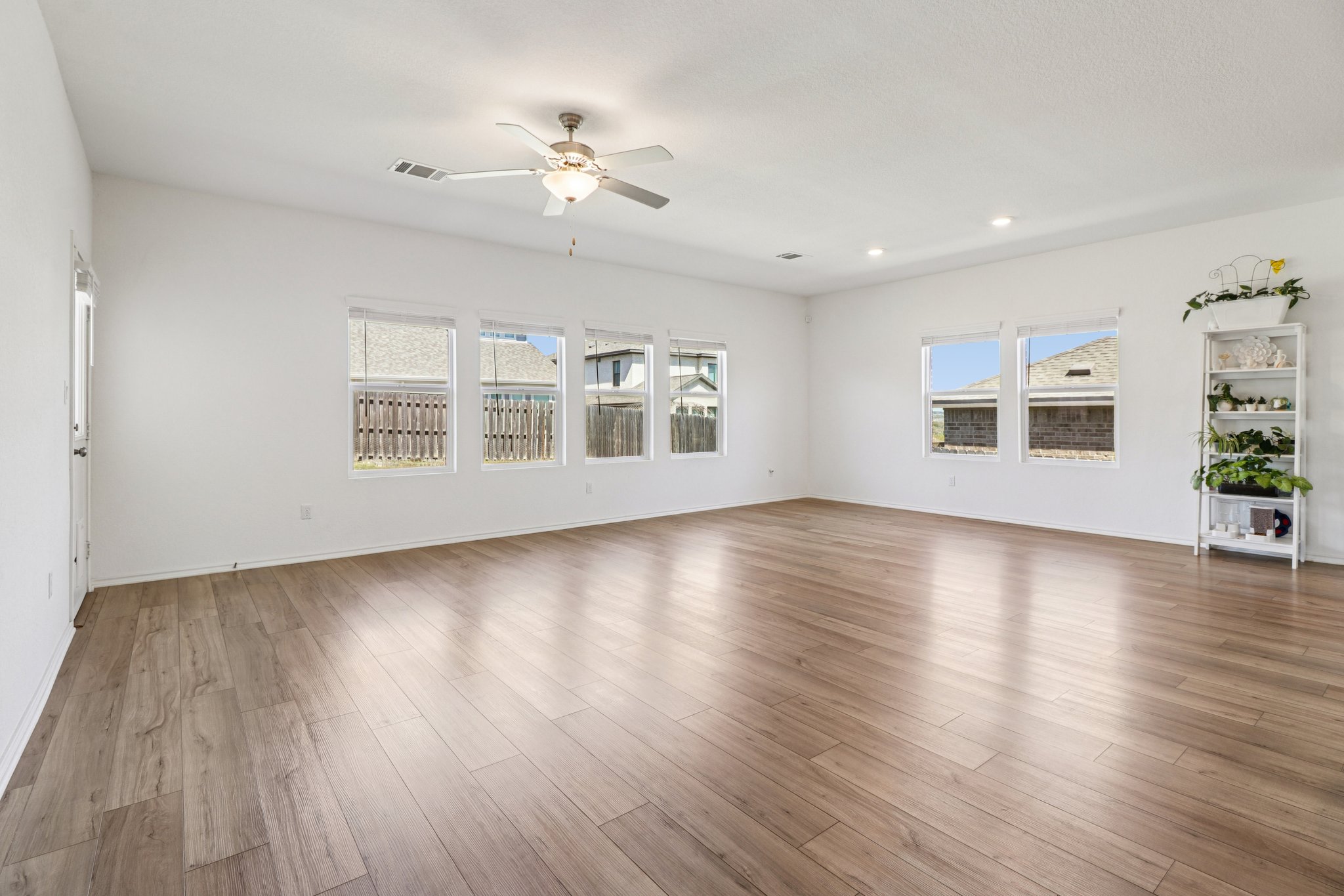 1201 Mallow Road Leander, TX 78641 - Photo 8 of 40 Unfurnished living room with ceiling fan, light wood-style flooring, healthy amount of natural light, and recessed lighting