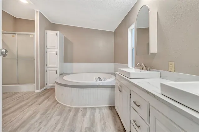 a spacious bathroom with a tub sink and mirror