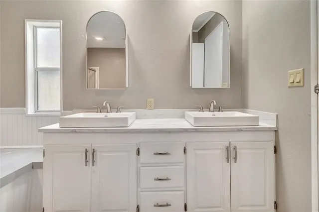 a bathroom with a double vanity sink and a mirror