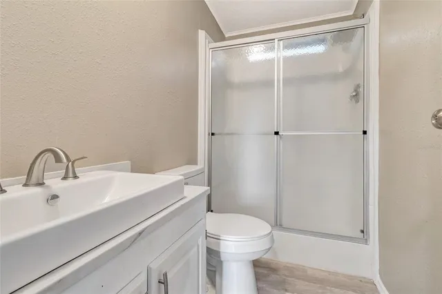 a bathroom with a sink a toilet and shower