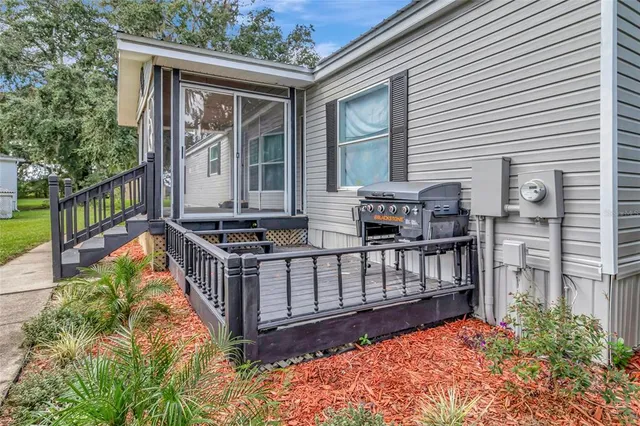 a view of house with wooden deck and furniture