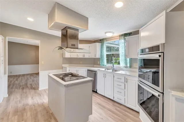 a kitchen with stainless steel appliances granite countertop a sink and a stove
