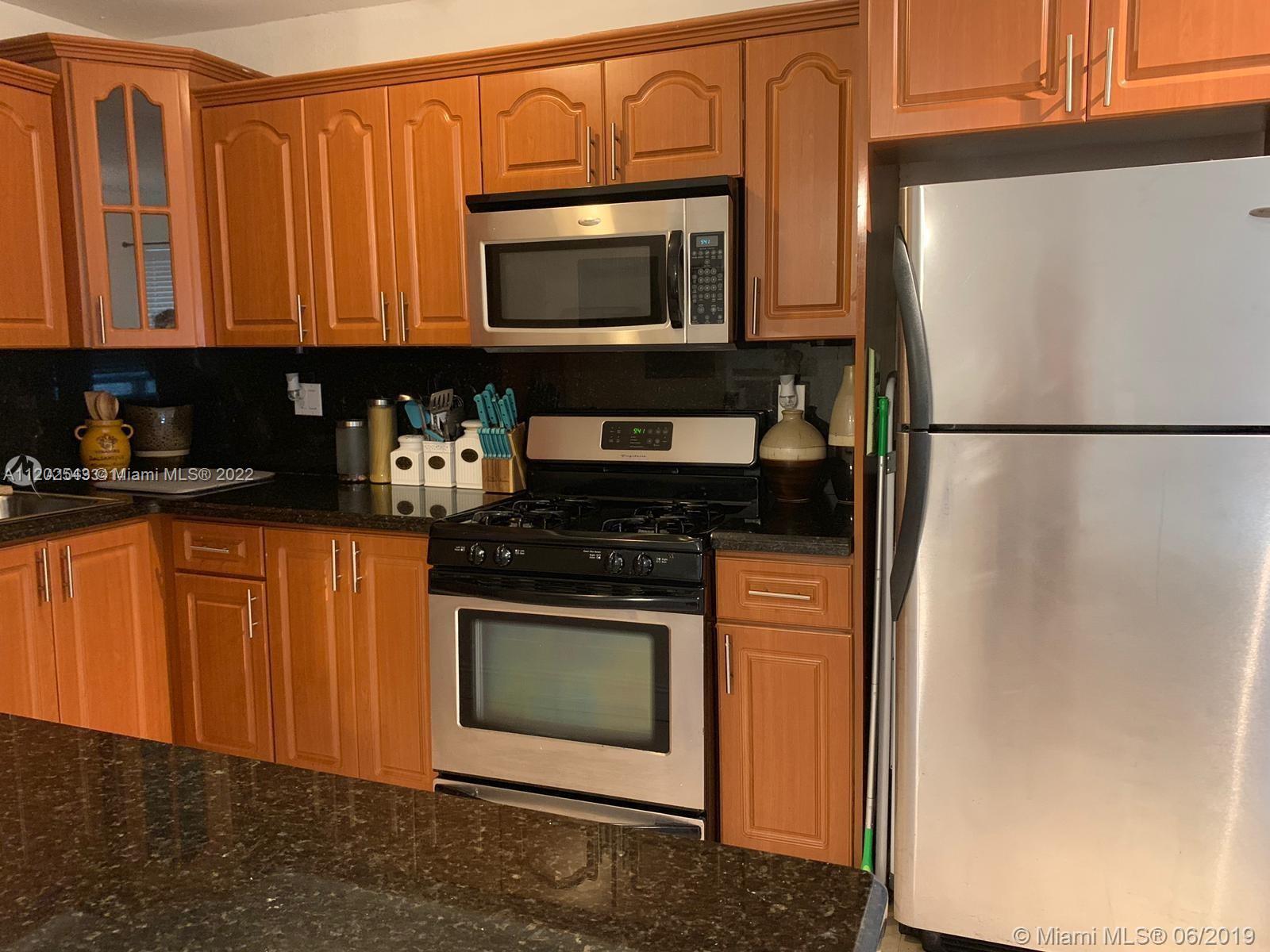 a kitchen with stainless steel appliances granite countertop a refrigerator stove top oven