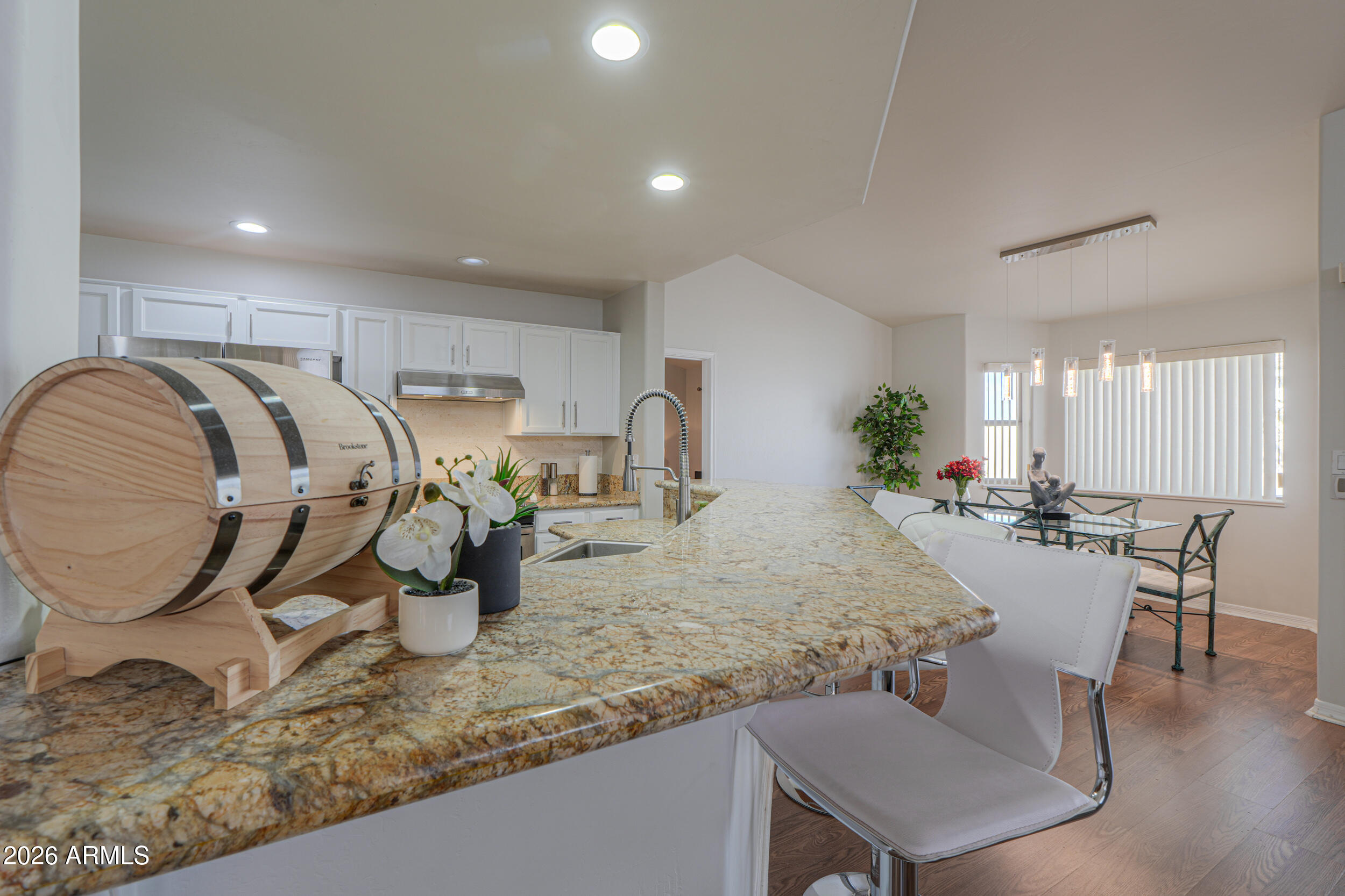 5830 East McKellips Road, Unit 27 Mesa, AZ 85215 - Photo 13 of 47 a very nice looking dining room with kitchen island granite countertop a table chairs and a wooden floor