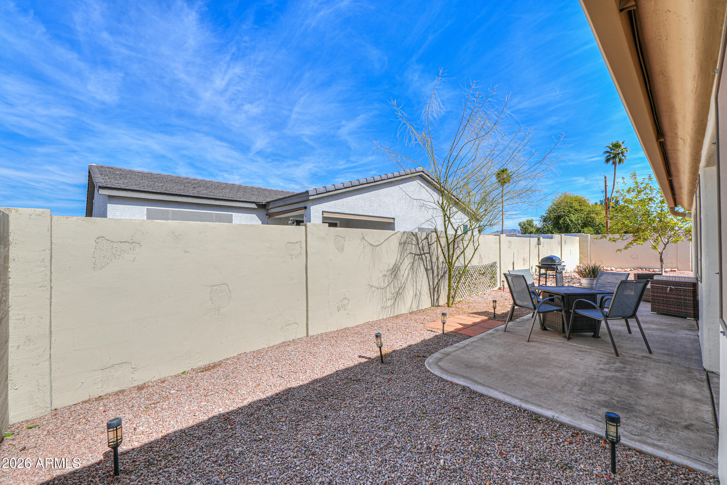 5830 East McKellips Road, Unit 27 Mesa, AZ 85215 - Photo 33 of 47 a backyard of a house with table and chairs