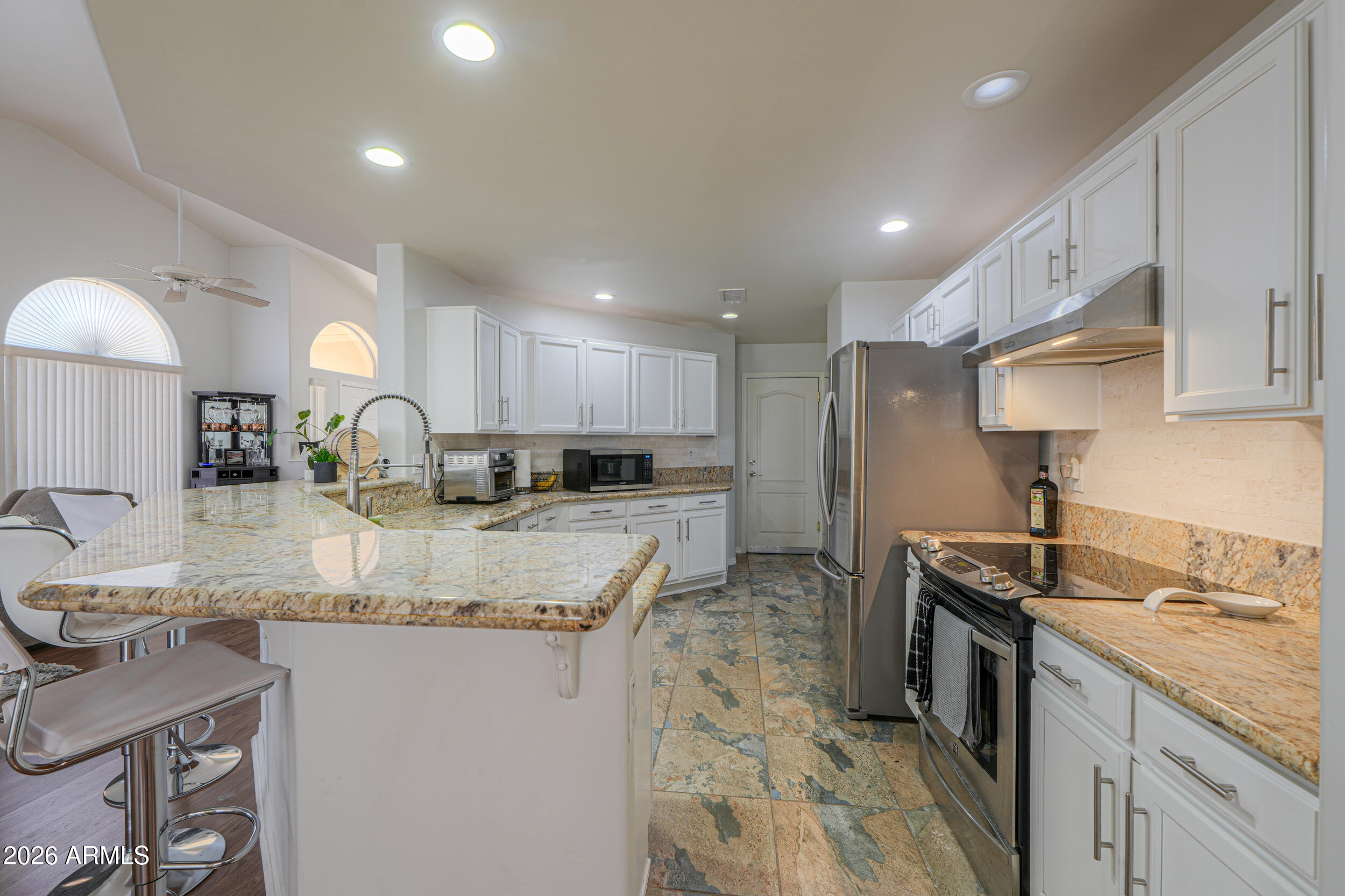 5830 East McKellips Road, Unit 27 Mesa, AZ 85215 - Photo 3 of 47 a kitchen with stainless steel appliances granite countertop sink stove refrigerator and cabinets