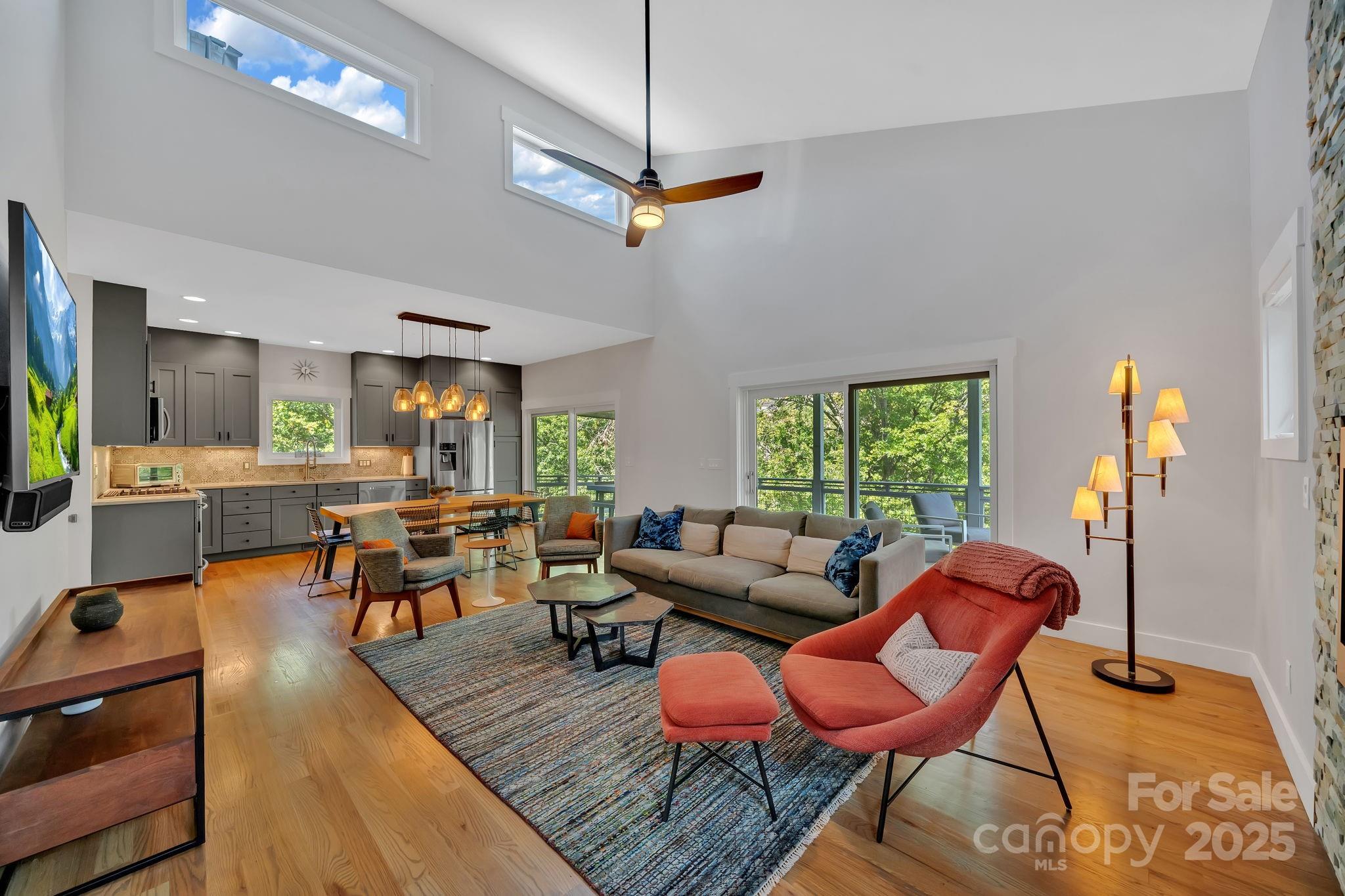 8 Birdhouse Row Asheville, NC 28801 - Photo 15 of 46 a living room with furniture a rug and a chandelier