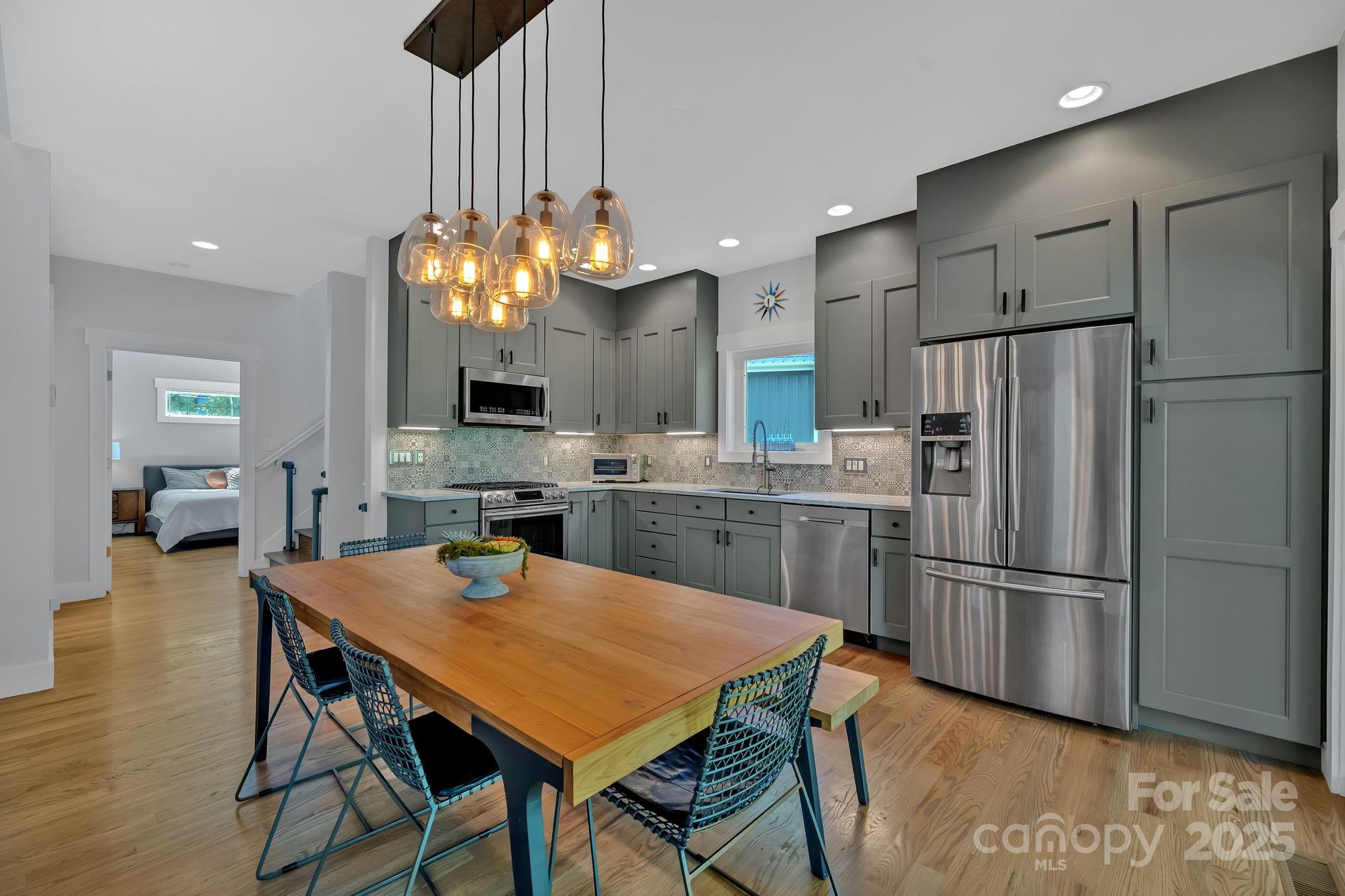8 Birdhouse Row Asheville, NC 28801 - Photo 20 of 46 a kitchen with refrigerator a sink and chairs