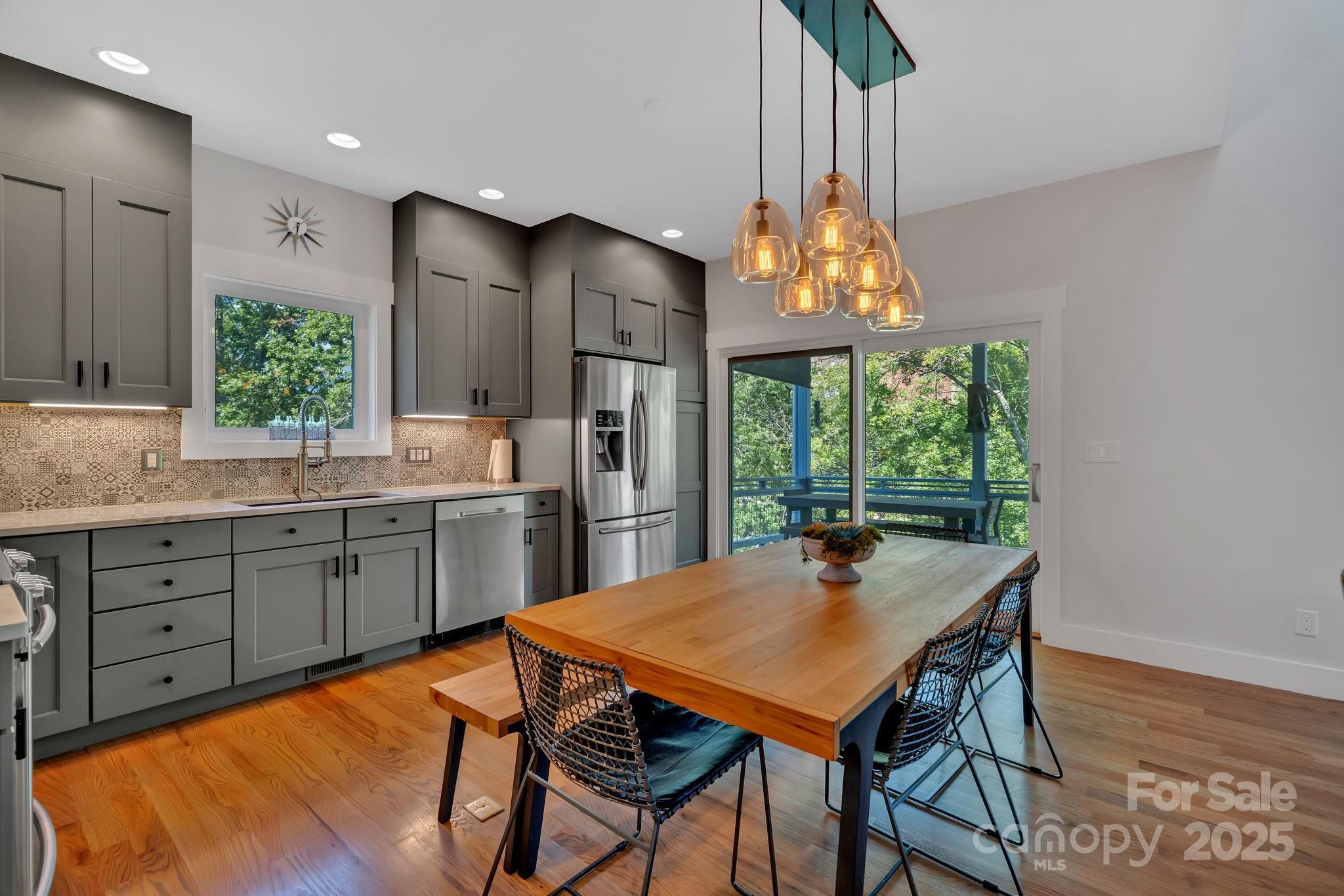 8 Birdhouse Row Asheville, NC 28801 - Photo 24 of 46 a kitchen with stainless steel appliances granite countertop a stove a sink dishwasher and a refrigerator with wooden floor