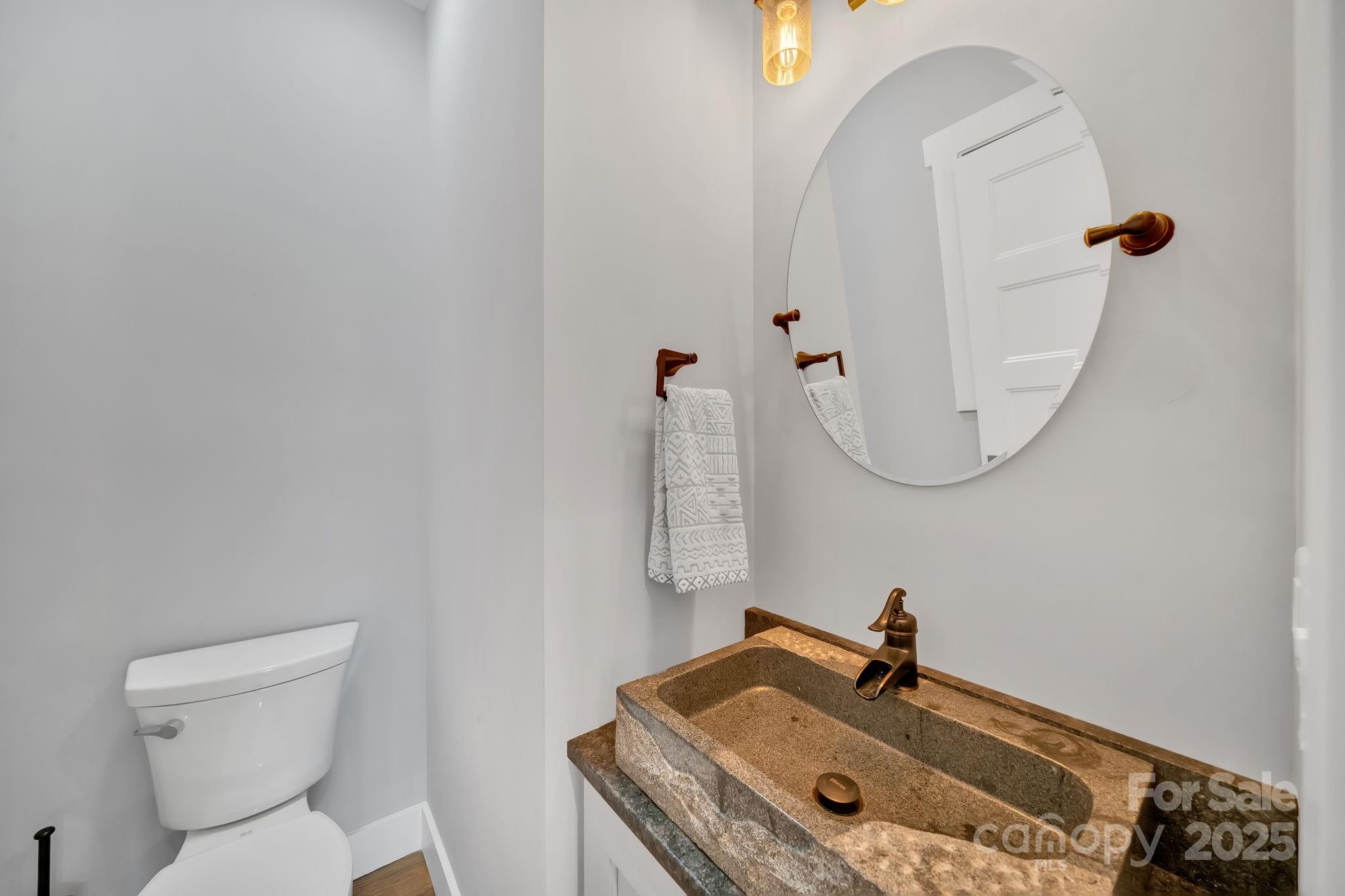8 Birdhouse Row Asheville, NC 28801 - Photo 25 of 46 a bathroom with a granite countertop sink a toilet and a mirror