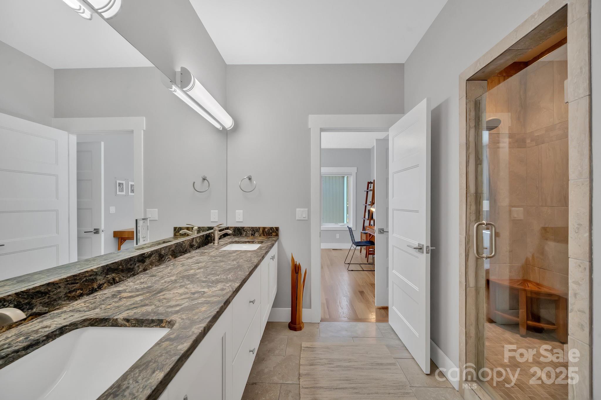 8 Birdhouse Row Asheville, NC 28801 - Photo 31 of 46 a bathroom with a granite countertop sink a mirror and a shower