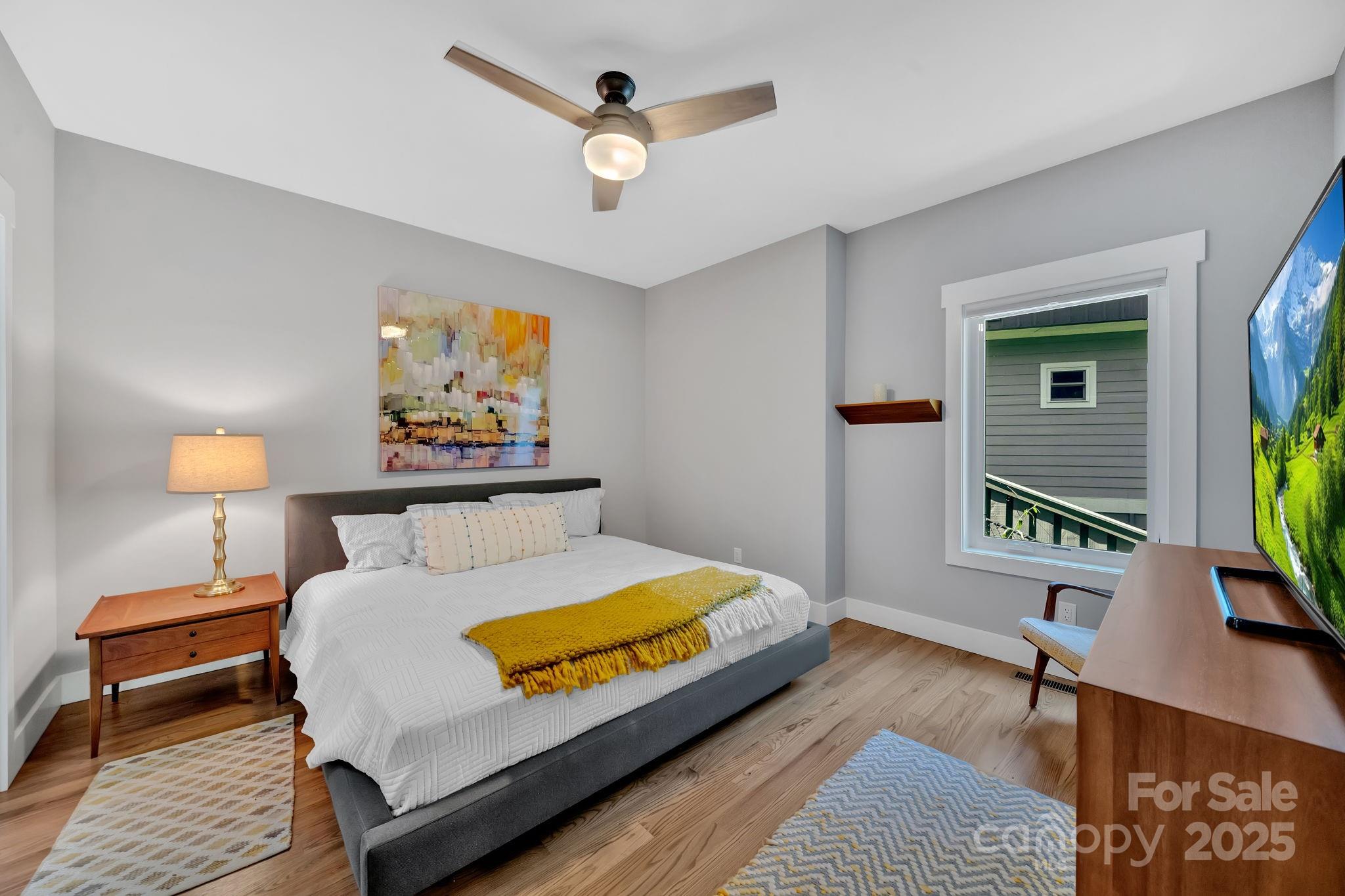 8 Birdhouse Row Asheville, NC 28801 - Photo 35 of 46 a bedroom with a bed a dresser and potted plants with the wooden floor