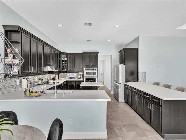 a large kitchen with a stove top oven sink and cabinets