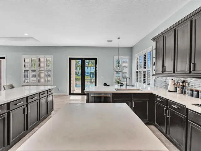 a kitchen with stainless steel appliances granite countertop a sink a stove a refrigerator and cabinets