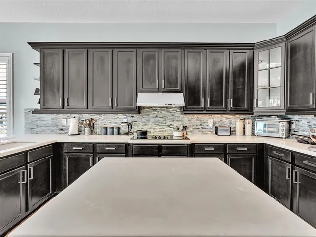 a large kitchen with cabinets stainless steel appliances and a counter top space