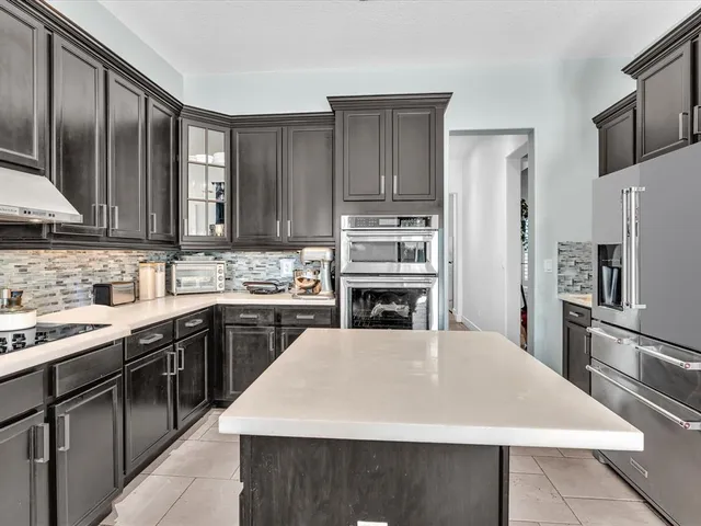 a living room with furniture a chandelier and a floor to ceiling window
