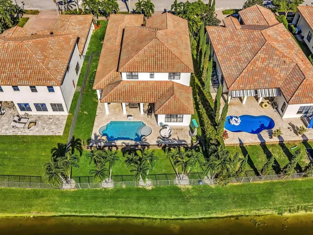 an aerial view of a residential houses with yard and swimming pool
