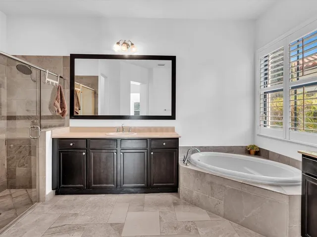a bathroom with a granite countertop sink a toilet a mirror and a tub