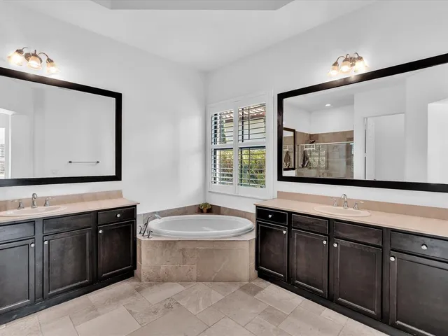 a bathroom with a granite countertop bathtub sink and mirror