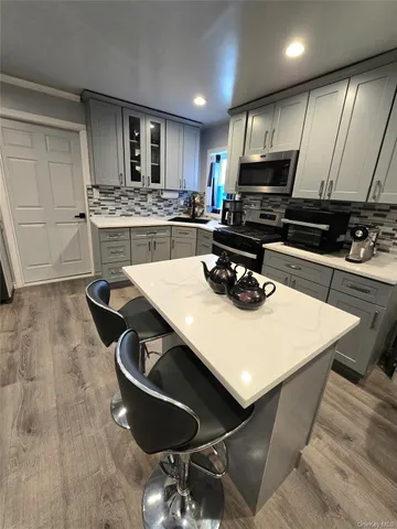 a kitchen with stainless steel appliances a stove sink microwave and cabinets