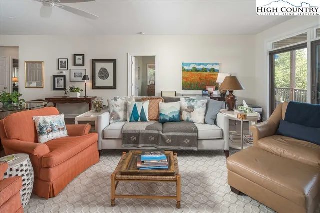 a living room with furniture a rug and a large window