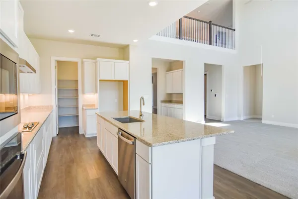 a kitchen with granite countertop a sink stove and refrigerator