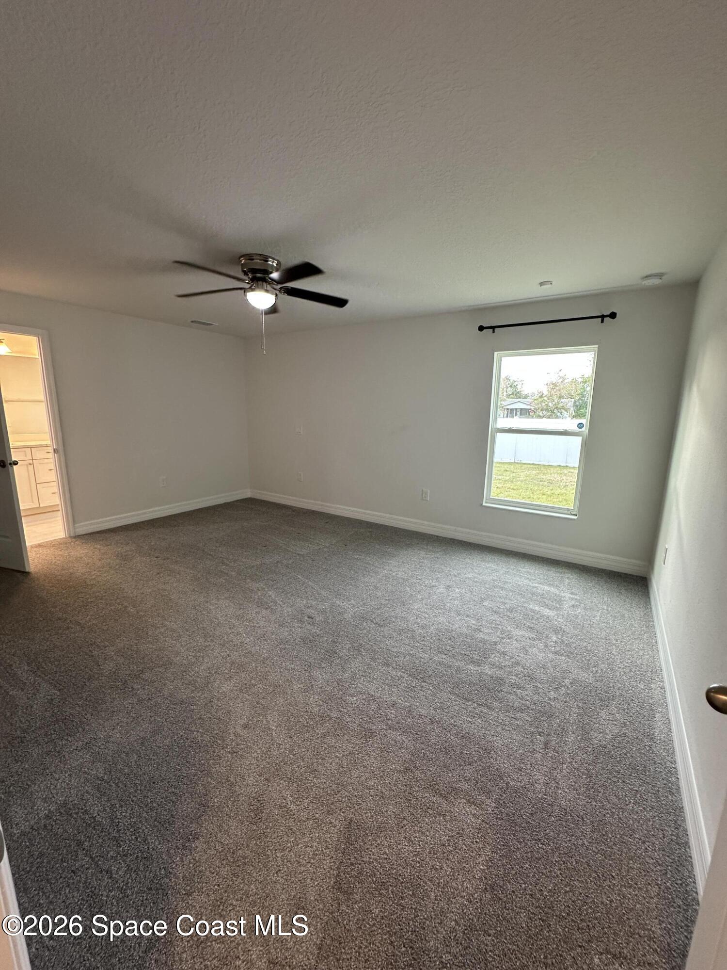 650 Rockinghorse Road Melbourne, FL 32935 - Photo 12 of 16 an empty room with windows and fan