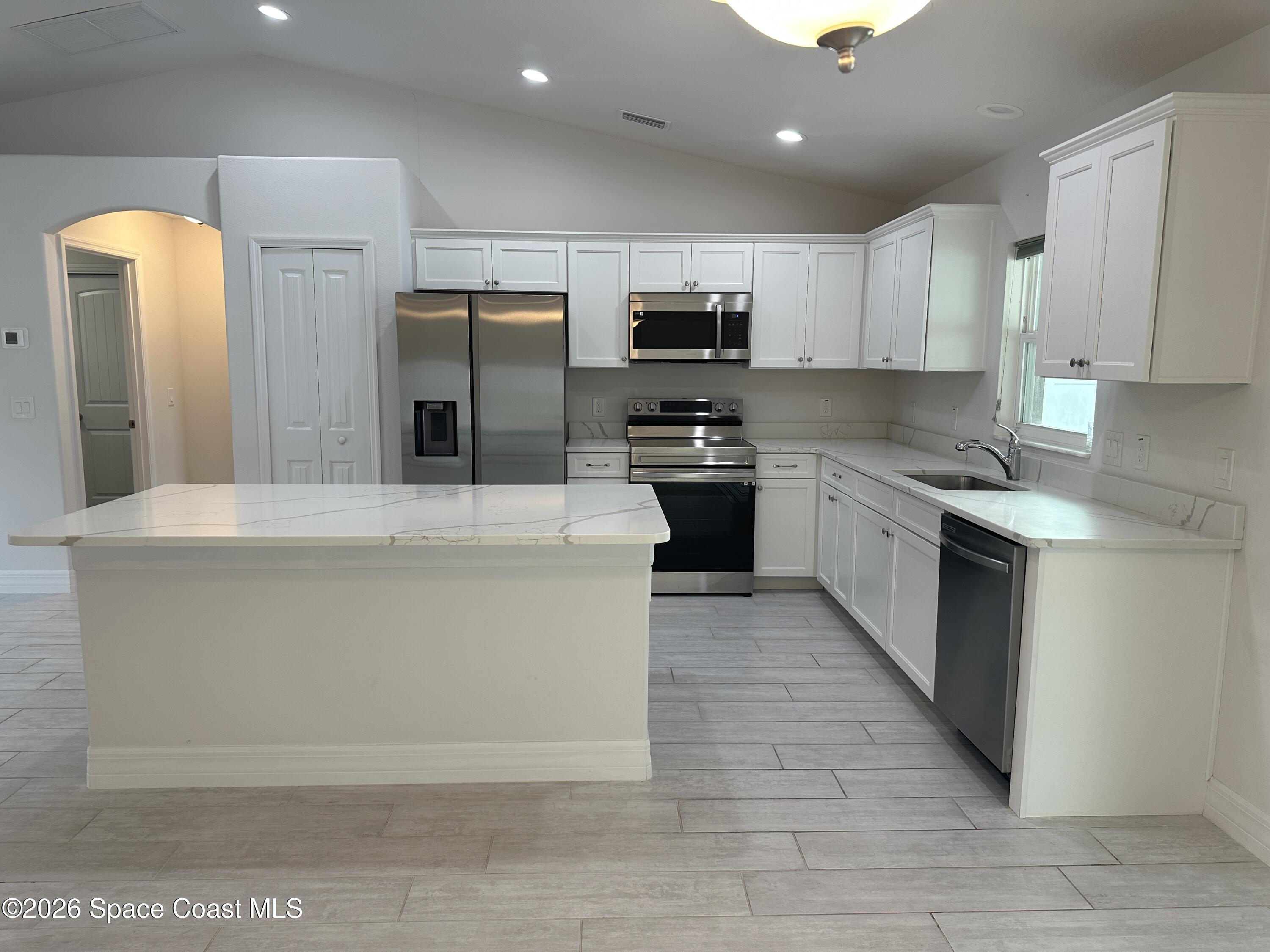 650 Rockinghorse Road Melbourne, FL 32935 - Photo 6 of 16 a large kitchen with stainless steel appliances granite countertop a stove a sink dishwasher a refrigerator and a oven