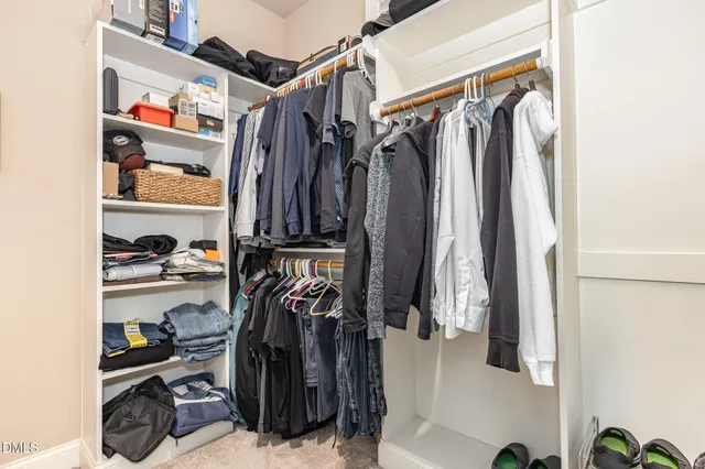 a view of walk in closet with clothes and shoes