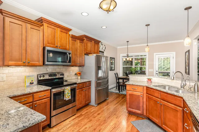 a kitchen with stainless steel appliances granite countertop a sink stove and refrigerator
