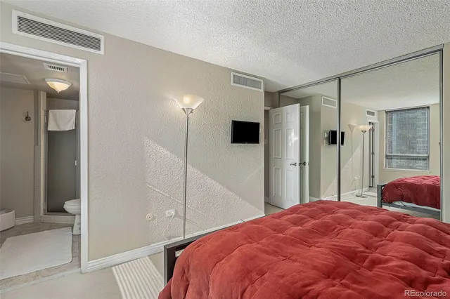 a bedroom with a bed and a large mirror