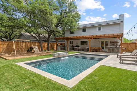 a view of a house with swimming pool and sitting area