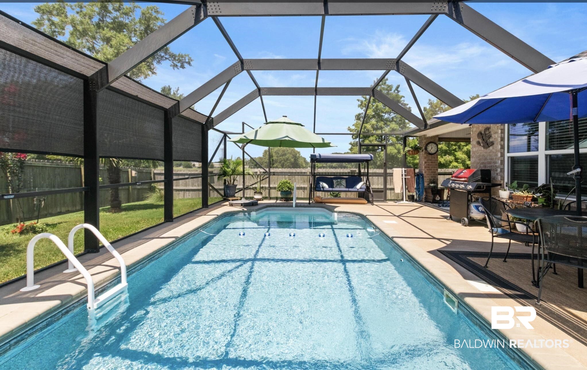 1676 Abbey Loop Foley, AL 36535 - Photo 13 of 31 Screened enclosure featuring a rectangular swimming pool with white handrails, a concrete pool deck, and a covered patio area