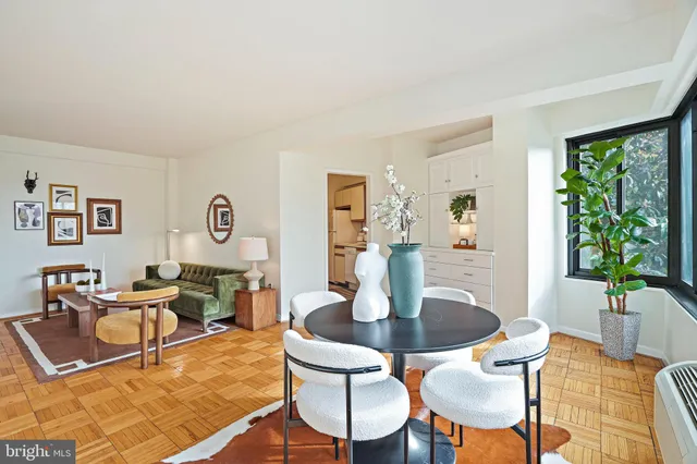 a dining room with wooden floor and a potted plant