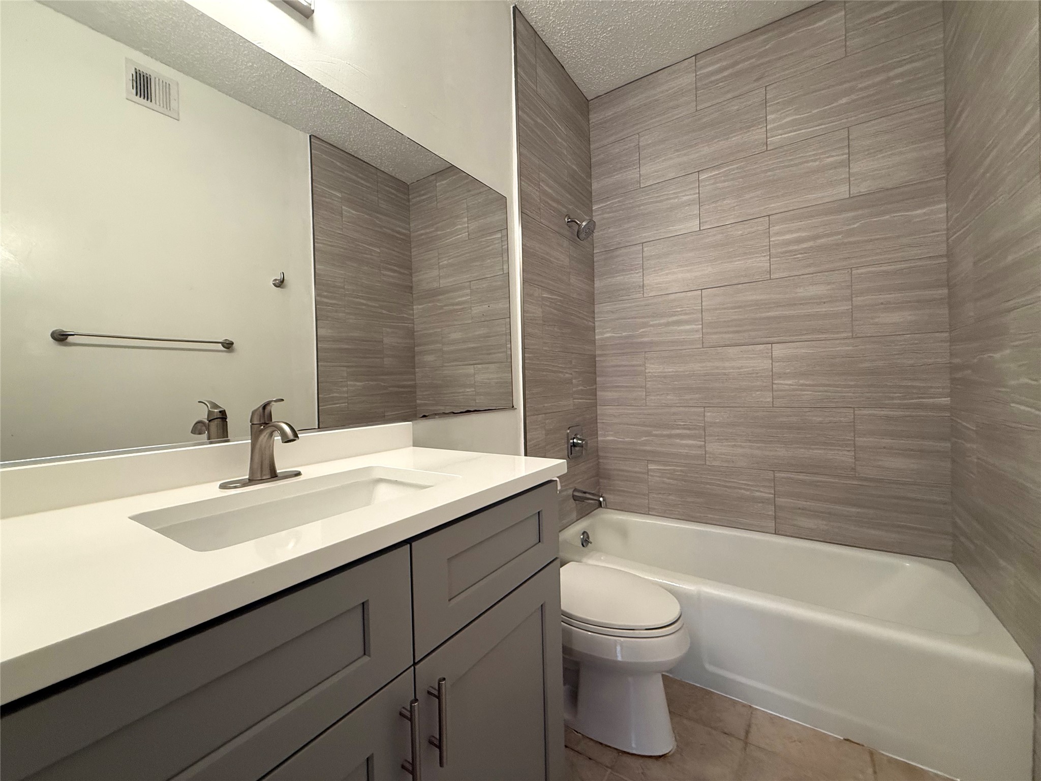 203 East 31st Street, Unit 101 Austin, TX 78705 - Photo 19 of 24 Bathroom featuring a vanity with a white countertop and rectangular integrated sink, brushed nickel faucet, and gray shaker-style cabinetry with brushed nickel hardware