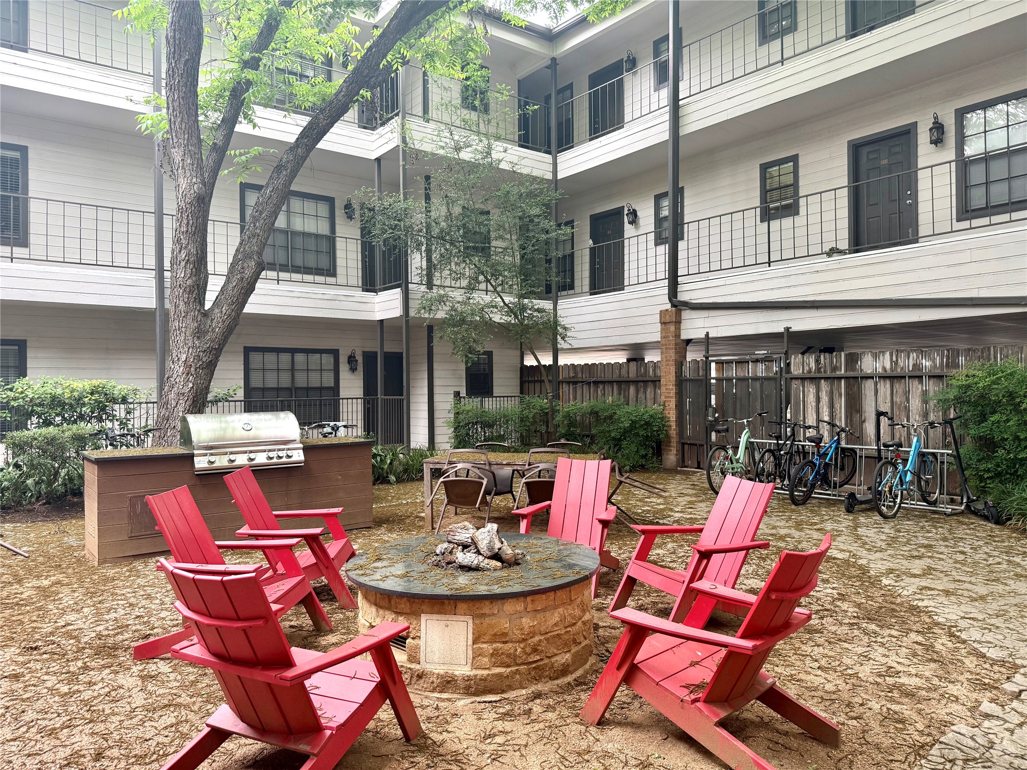 203 East 31st Street, Unit 101 Austin, TX 78705 - Photo 4 of 24 Outdoor amenity space featuring a stone fire pit, built-in BBQ station with counter, and a dedicated bicycle rack