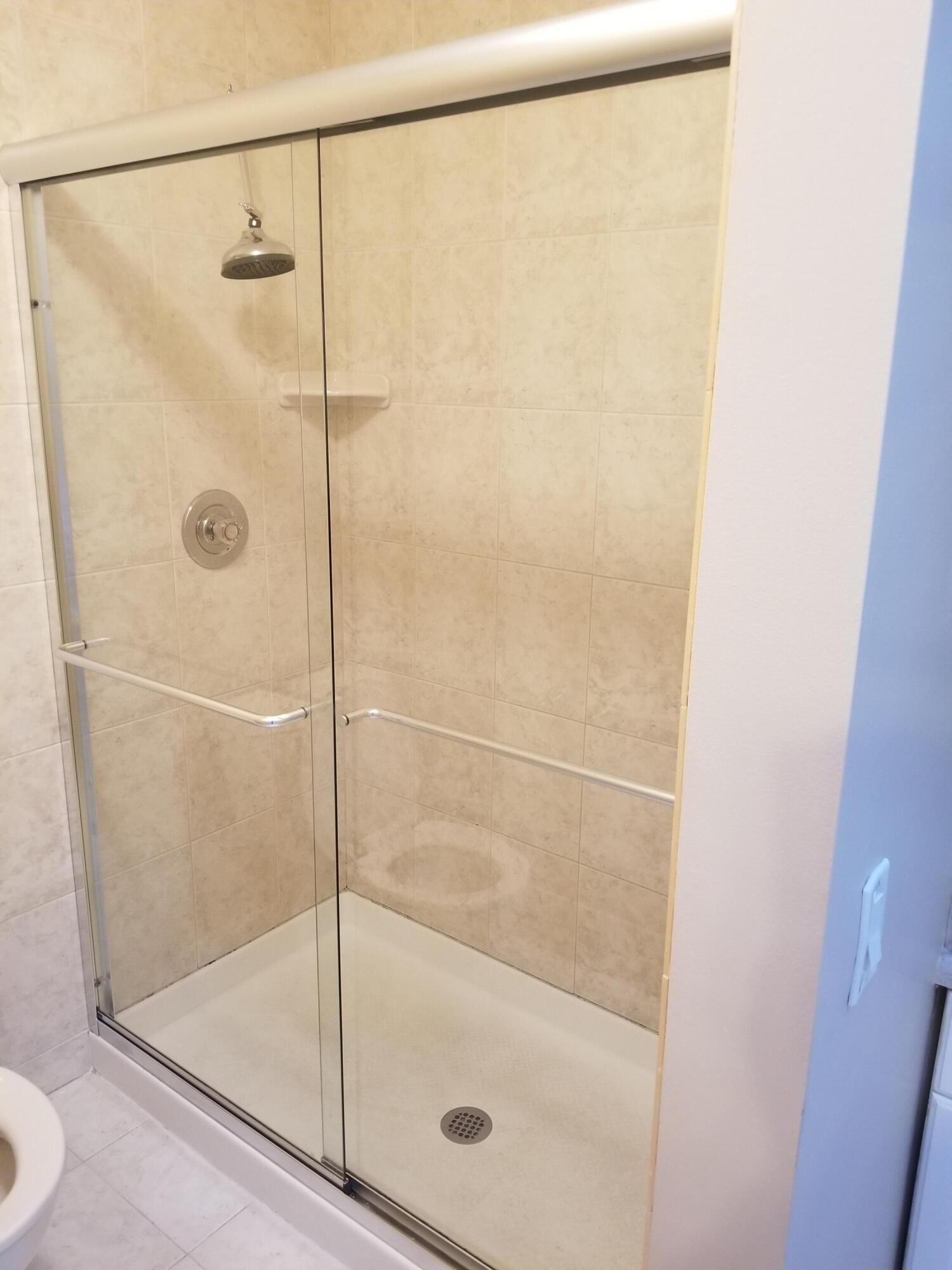 23312 Southwest 53rd Avenue, Unit C Boca Raton, FL 33433 - Photo 11 of 14 a bathroom with a glass shower door