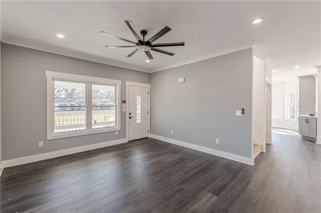 a view of an empty room with a window and wooden floor