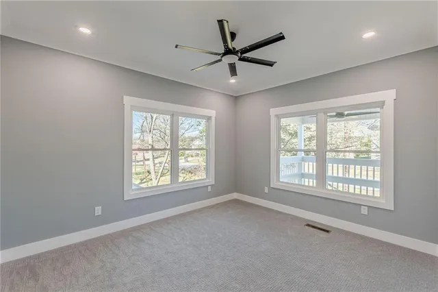 a view of empty room with a ceiling fan and window