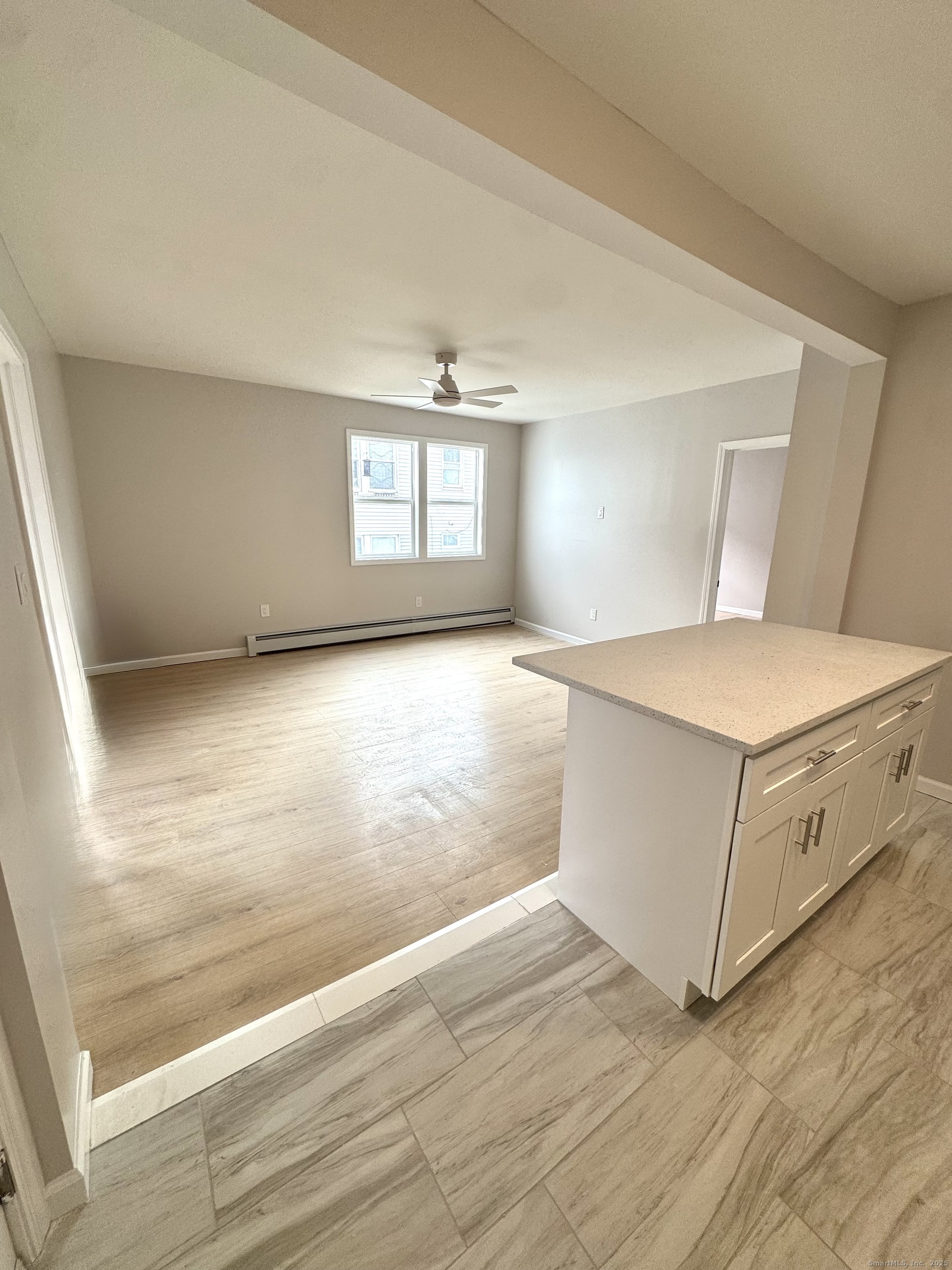 24 Woodbury Avenue, Unit 1A Norwalk, CT 06850 - Photo 3 of 7 a view of an empty room with window and wooden floor