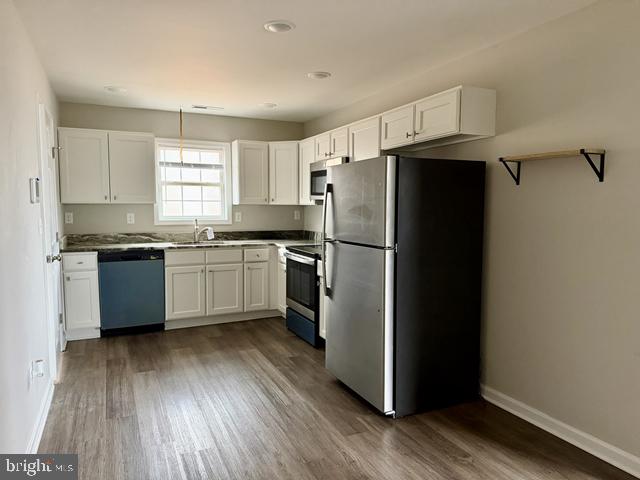 2120 Ruxton Drive Salisbury, MD 21801 - Photo 8 of 18 a kitchen with stainless steel appliances a refrigerator a sink cabinets and wooden floor