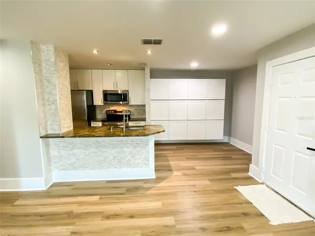 a view of kitchen with microwave and cabinets
