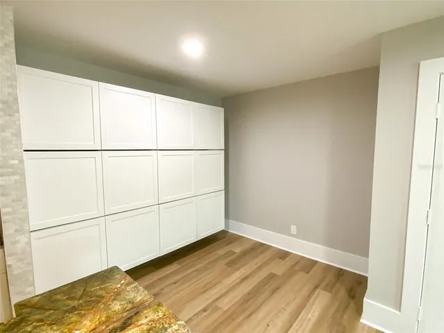 a view of a closet area with wooden floor