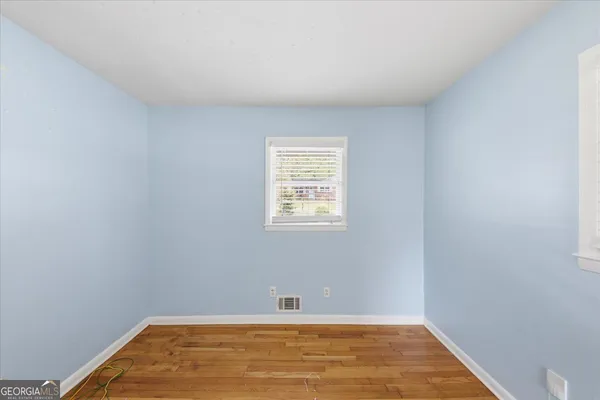 a view of a room with wooden floor and a window
