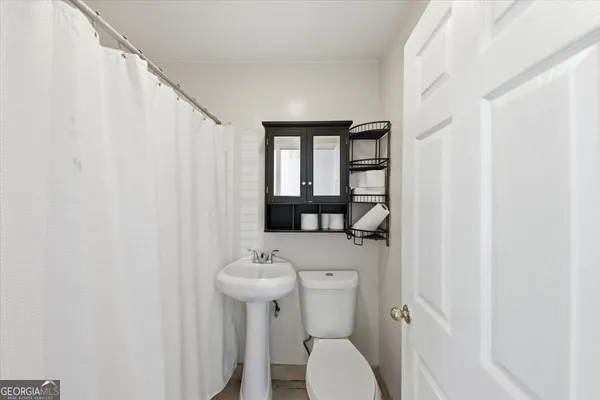 a bathroom with a sink a toilet and a mirror