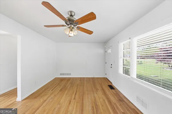 a view of a room with wooden floor and window