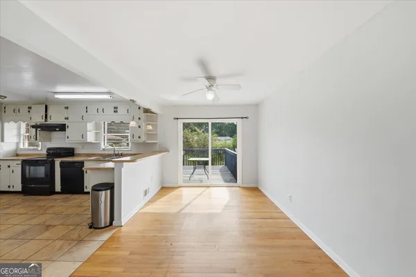 a large white kitchen with kitchen island granite countertop a large counter top space a sink and stainless steel appliances