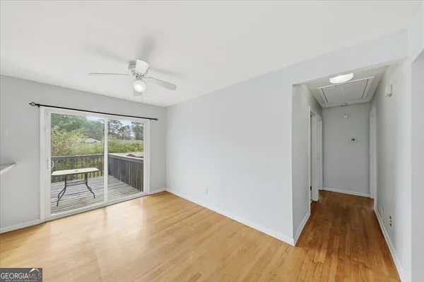 a view of empty room with wooden floor and fan