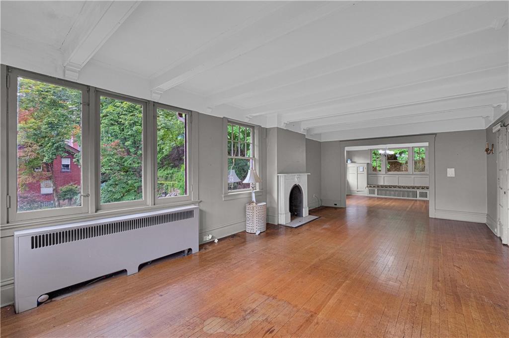 4283 Andover Terrace Pittsburgh, PA 15213 - Photo 15 of 25 a view of a big room with wooden floor a fireplace and windows